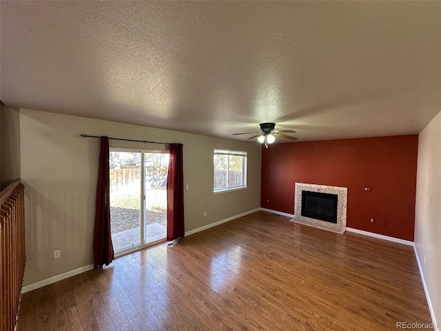 unfurnished living room featuring a textured ceiling, ceiling fan, and dark hardwood / wood-style floors