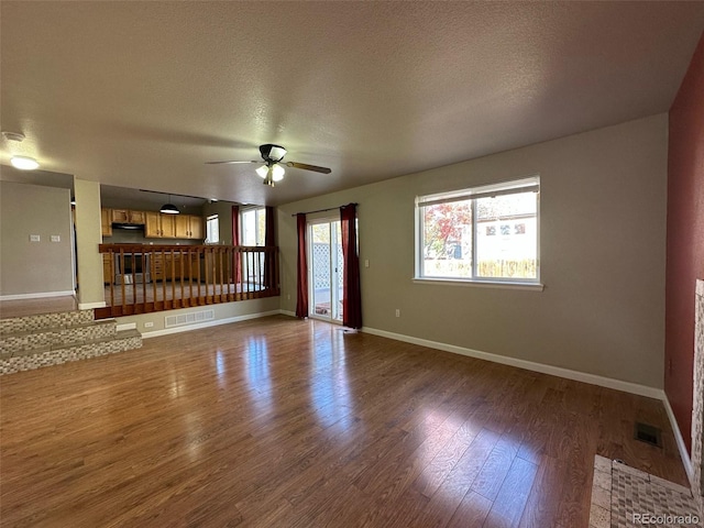 spare room featuring ceiling fan, dark hardwood / wood-style floors, and a textured ceiling