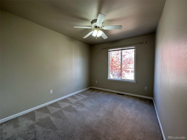 unfurnished room featuring dark colored carpet and ceiling fan