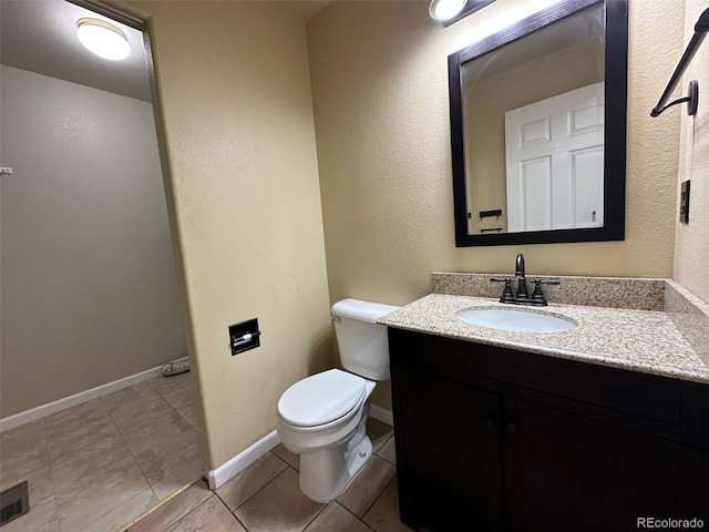 bathroom featuring vanity, toilet, and tile floors