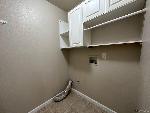 clothes washing area featuring electric dryer hookup, washer hookup, light tile floors, and cabinets