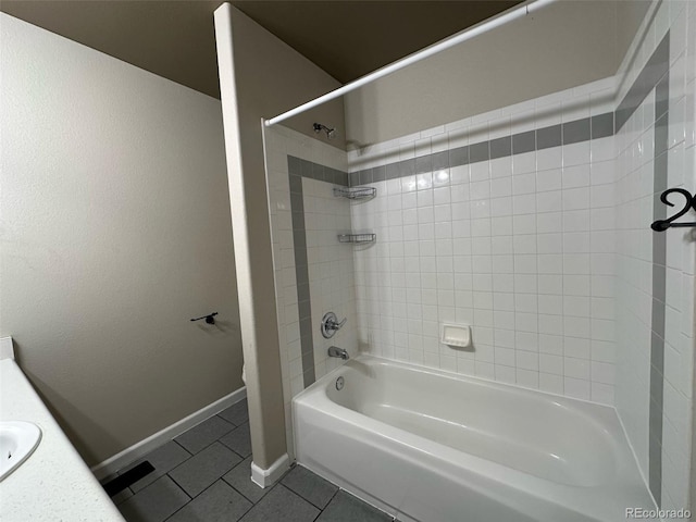 bathroom with tile flooring, tiled shower / bath combo, and vanity