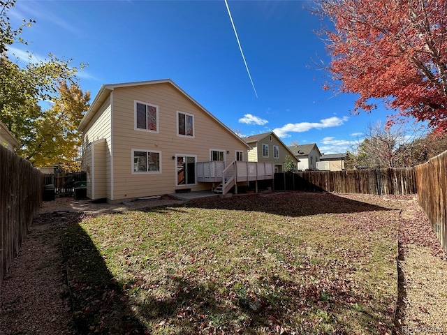 rear view of property with a deck and a yard