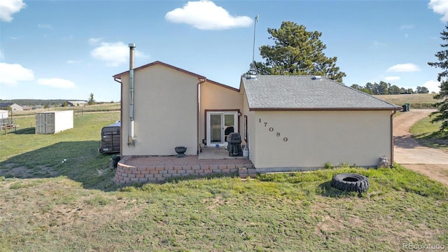 rear view of property with stucco siding and a lawn