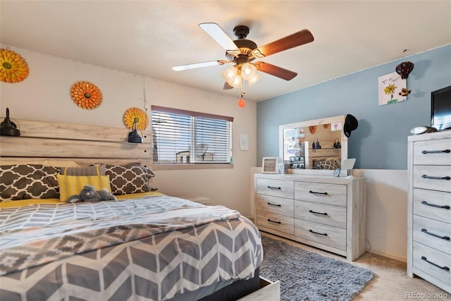 bedroom featuring light colored carpet and a ceiling fan