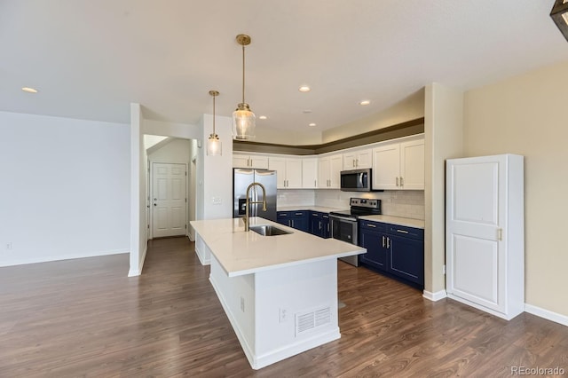 kitchen with stainless steel appliances, sink, blue cabinetry, pendant lighting, and white cabinetry