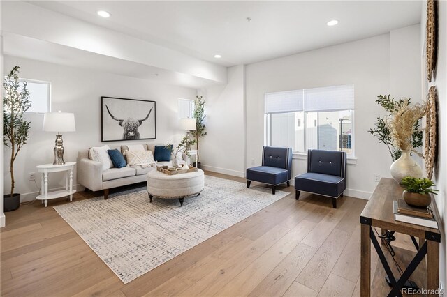 living area with recessed lighting, plenty of natural light, light wood-style floors, and baseboards