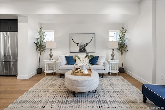 living area with baseboards and wood finished floors