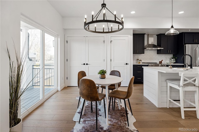 dining space featuring a chandelier, light wood-style floors, recessed lighting, and a wealth of natural light