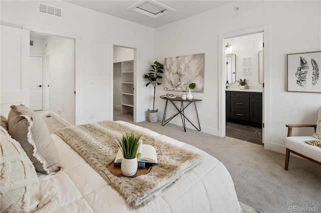 bedroom with a closet, light carpet, a spacious closet, attic access, and visible vents