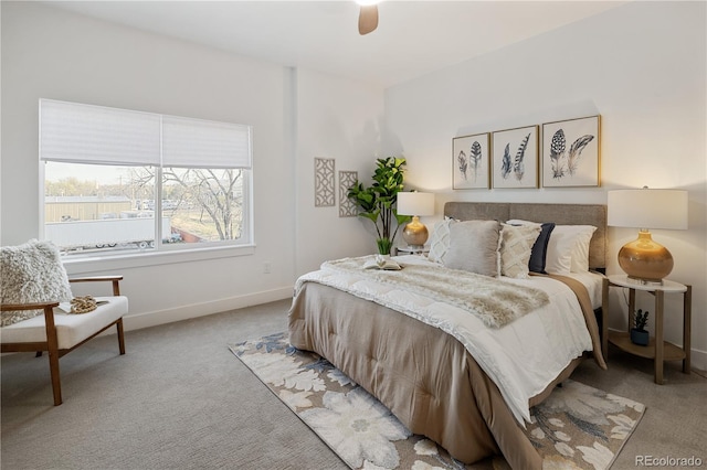 bedroom featuring light colored carpet, baseboards, and a ceiling fan