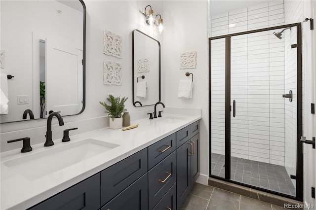 full bath with a stall shower, double vanity, a sink, and tile patterned floors