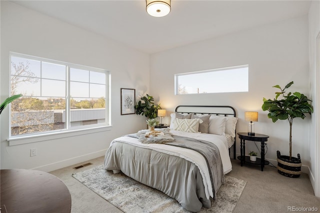 carpeted bedroom featuring visible vents and baseboards