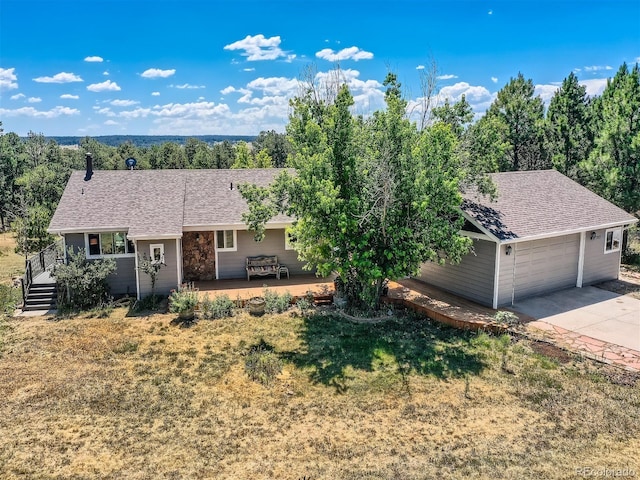 ranch-style home featuring a wooden deck, a garage, and a front lawn