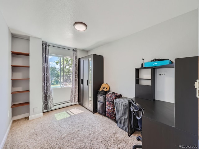 carpeted office space with a baseboard radiator and a textured ceiling