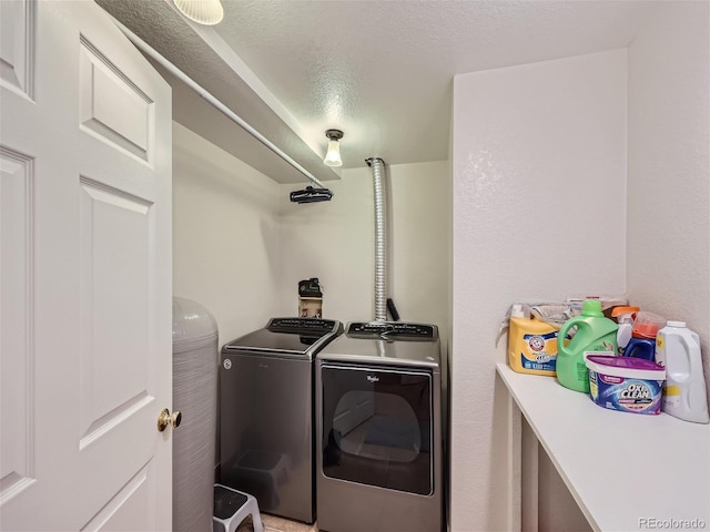 clothes washing area featuring independent washer and dryer and a textured ceiling