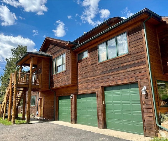 31755 Ponderosa Way, Evergreen, CO 80439 - view of home's exterior featuring a garage, asphalt driveway, and stairs