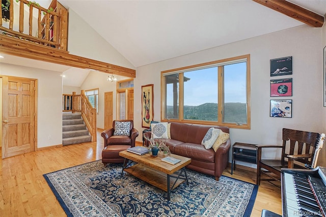 31755 Ponderosa Way, Evergreen, CO 80439 - living room featuring plenty of natural light, beam ceiling, stairway, wood finished floors, and high vaulted ceiling