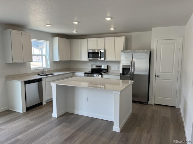 21996 E 39th Pl, Aurora, CO 80019 - kitchen with stainless steel appliances, a kitchen island, light wood-style floors, a sink, and recessed lighting