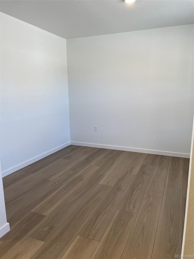21996 E 39th Pl, Aurora, CO 80019 - empty room with dark wood-style flooring and baseboards