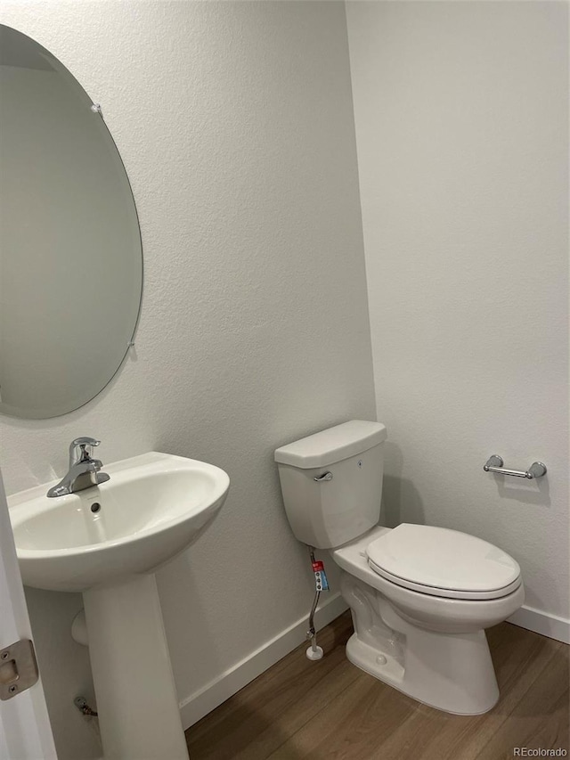 21996 E 39th Pl, Aurora, CO 80019 - half bath with wood finished floors, toilet, and baseboards