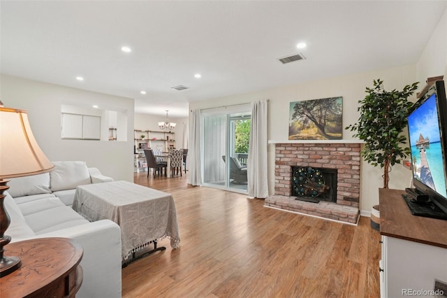 7305 S Xenia Cir Unit E, Centennial, CO 80112 - living area featuring light wood finished floors, a chandelier, recessed lighting, and a brick fireplace