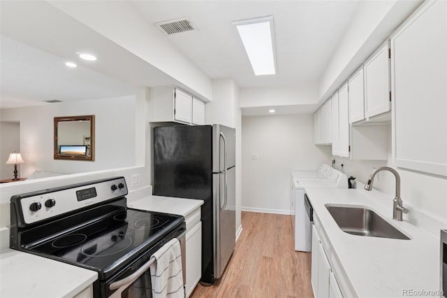 7305 S Xenia Cir Unit E, Centennial, CO 80112 - kitchen featuring appliances with stainless steel finishes, independent washer and dryer, white cabinetry, light wood-style floors, and light countertops