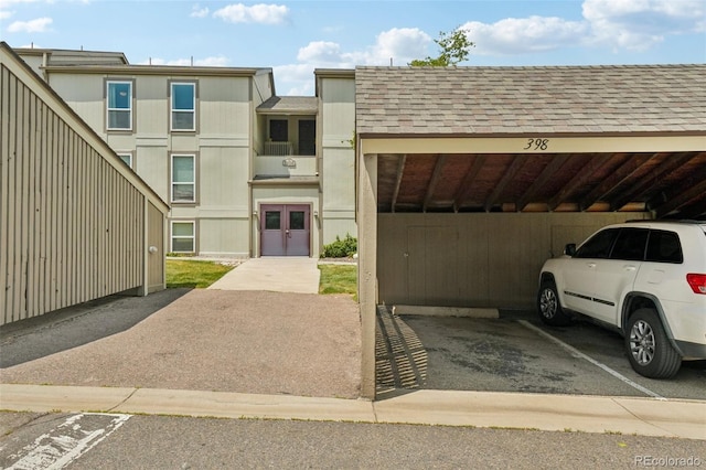 7305 S Xenia Cir Unit E, Centennial, CO 80112 - view of front of house with covered parking, french doors, and roof with shingles