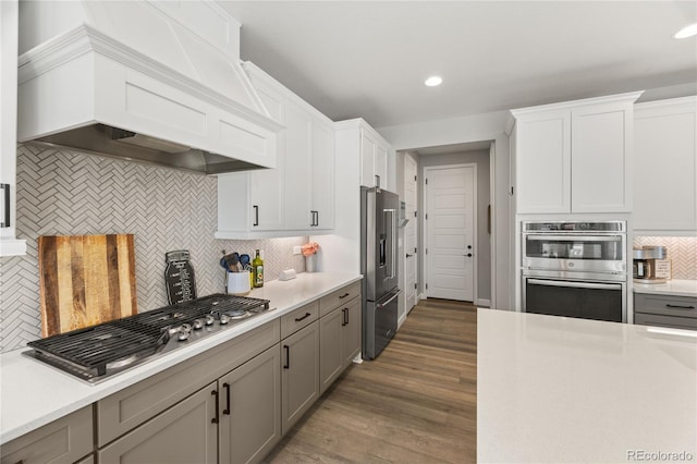 2576 Villageview Ln, Castle Rock, CO 80104 - kitchen featuring appliances with stainless steel finishes, premium range hood, tasteful backsplash, light countertops, and recessed lighting