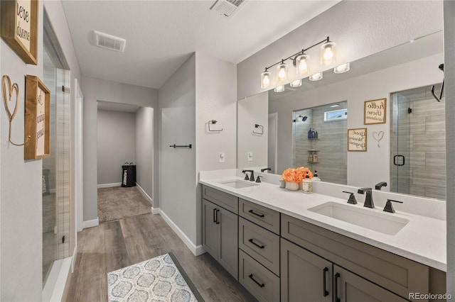 2576 Villageview Ln, Castle Rock, CO 80104 - bathroom featuring double vanity, a stall shower, wood finished floors, and baseboards
