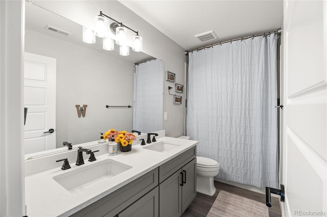 2576 Villageview Ln, Castle Rock, CO 80104 - bathroom with toilet, double vanity, wood finished floors, and a shower with shower curtain