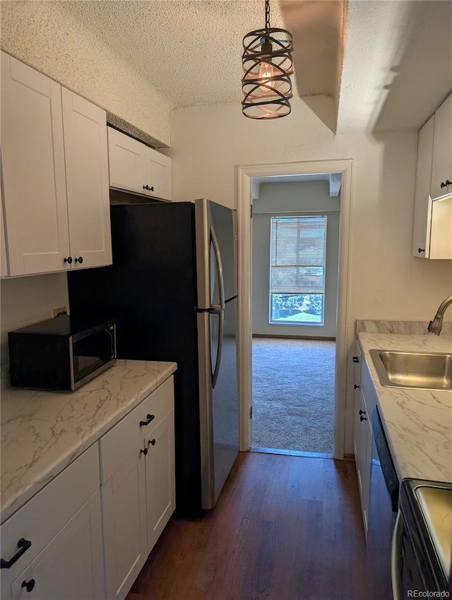 8060 E Girard Ave Unit 910, Denver, CO 80231 - kitchen with stainless steel microwave, dark wood-style floors, white cabinets, range, and a textured ceiling