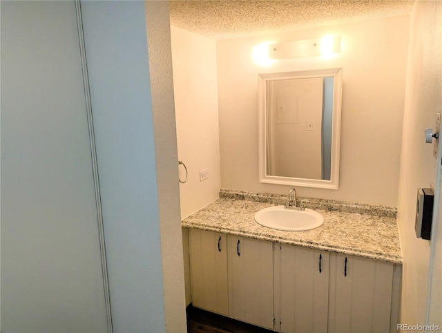 8060 E Girard Ave Unit 910, Denver, CO 80231 - bathroom with vanity and a textured ceiling