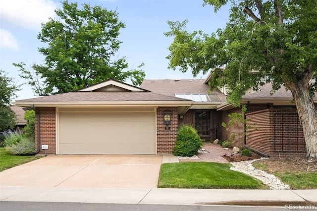 2800 S University Blvd Unit 19, Denver, CO 80210 - view of front of house with brick siding, a garage, concrete driveway, and roof with shingles