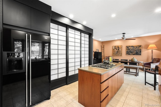 2800 S University Blvd Unit 19, Denver, CO 80210 - kitchen featuring high end black refrigerator, stainless steel gas cooktop, dark cabinetry, ceiling fan, and modern cabinets