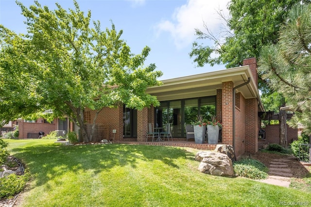 2800 S University Blvd Unit 19, Denver, CO 80210 - view of front of home with a front lawn, brick siding, a chimney, and covered porch