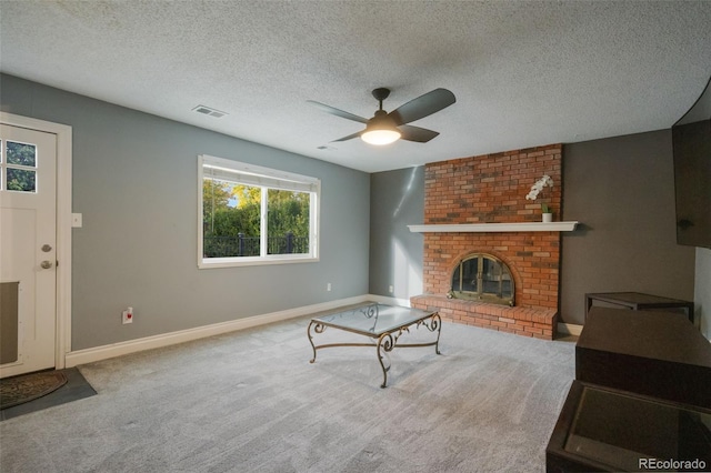 carpeted living room with a brick fireplace, a textured ceiling, and ceiling fan