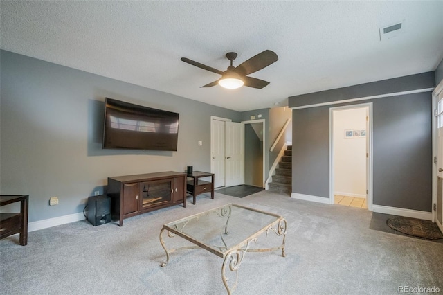 carpeted living room with a textured ceiling and ceiling fan