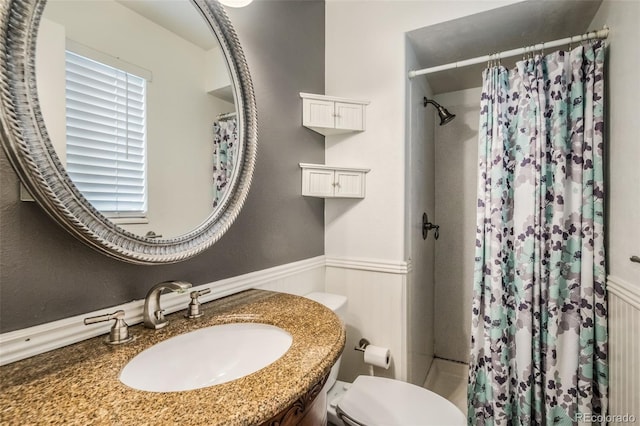 bathroom featuring vanity, toilet, and walk in shower