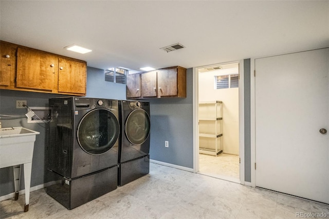 laundry room featuring cabinets and separate washer and dryer