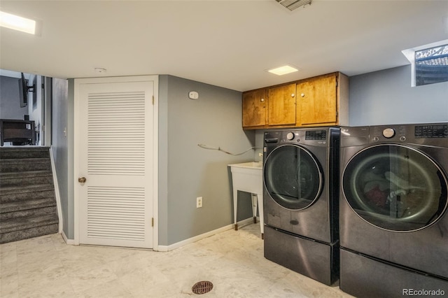 laundry area featuring washer and dryer and cabinets