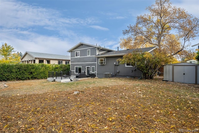 back of house featuring central air condition unit and a storage shed