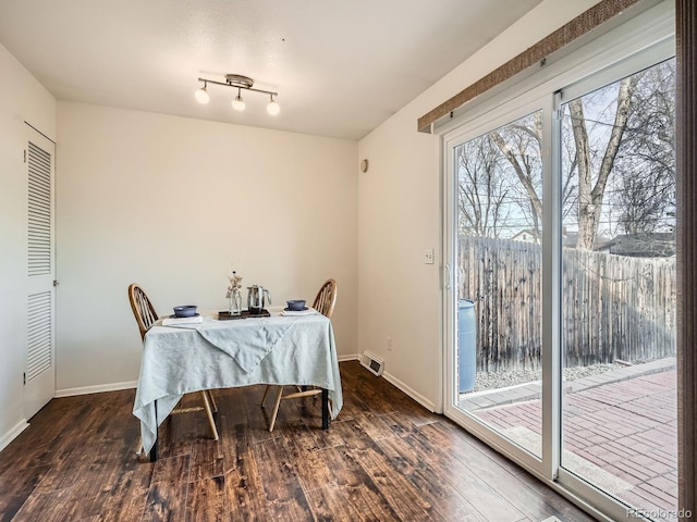 dining space featuring visible vents, baseboards, and wood finished floors