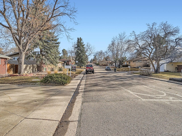 view of street featuring a residential view, curbs, and sidewalks