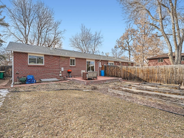 back of house featuring a patio area, brick siding, and fence