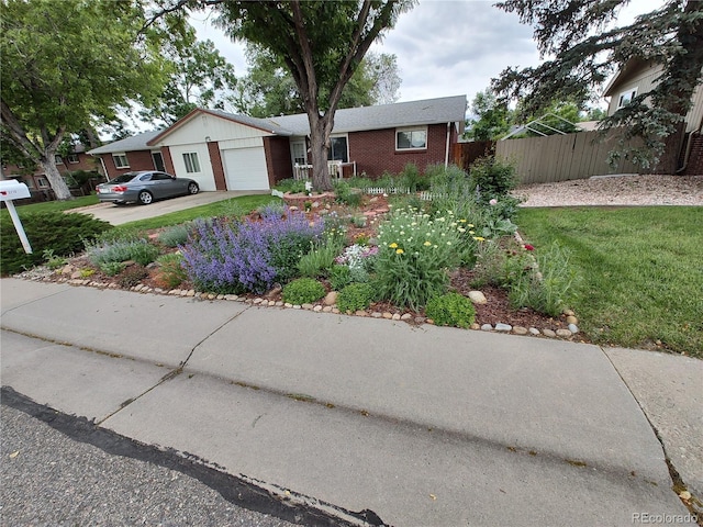 single story home featuring concrete driveway, an attached garage, fence, a front lawn, and brick siding