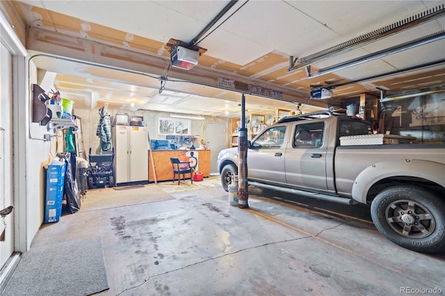 garage with white refrigerator and a garage door opener