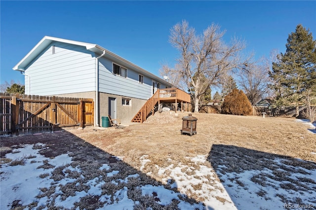 yard layered in snow with a wooden deck and a fire pit