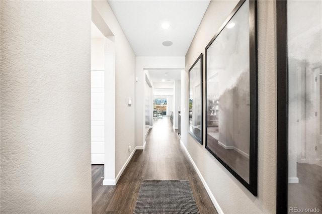 corridor with dark hardwood / wood-style flooring