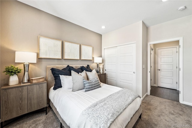 bedroom with a closet and dark colored carpet